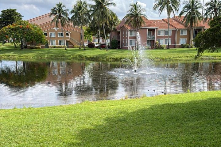 Lago com chafariz num condomínio residencial, com prédios ao fundo